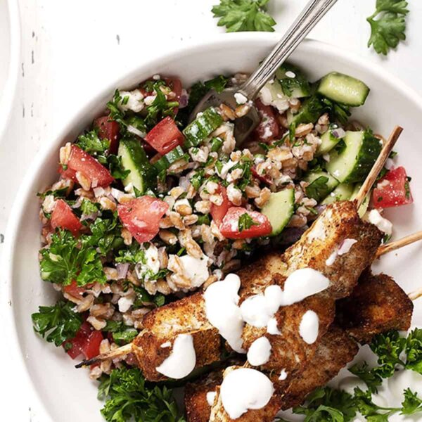 shawarma chicken on skewers on plate with tabbbouleh