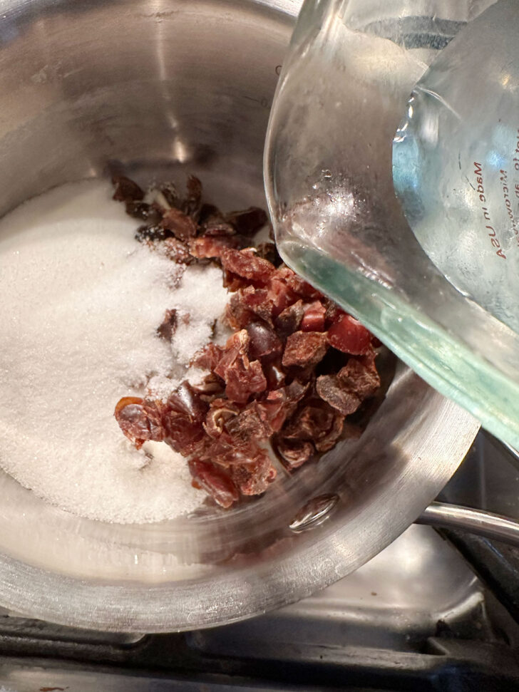 Adding date filling ingredients to saucepan.