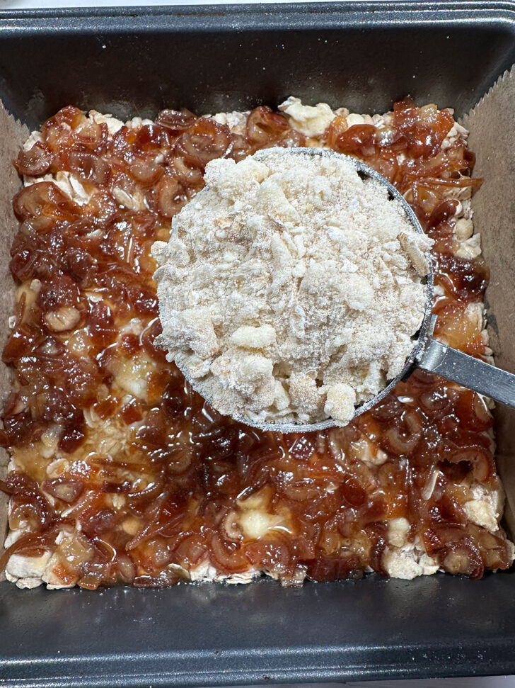 Baking pan after spreading date filling over and ready to scatter on the topping.