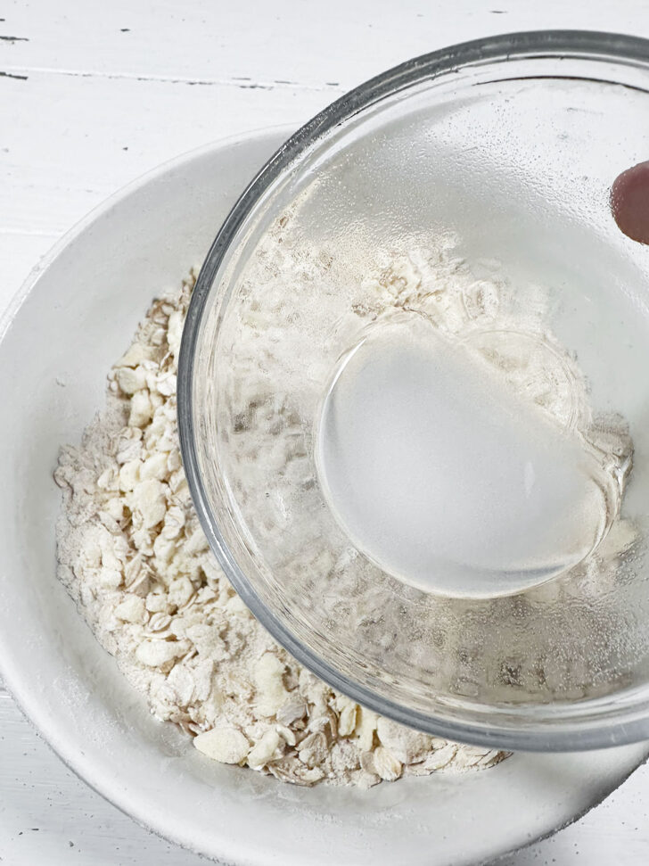 Drizzling the flour mixture with baking soda mixture.