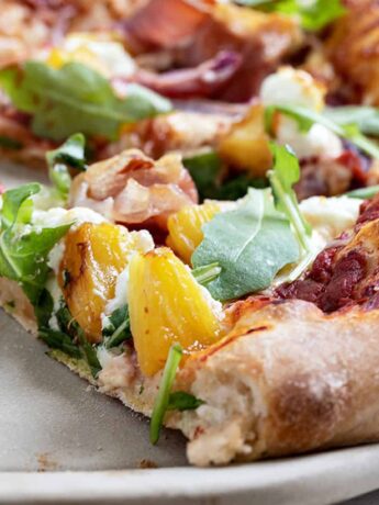 Hawaiian pizza on pizza stone sliced