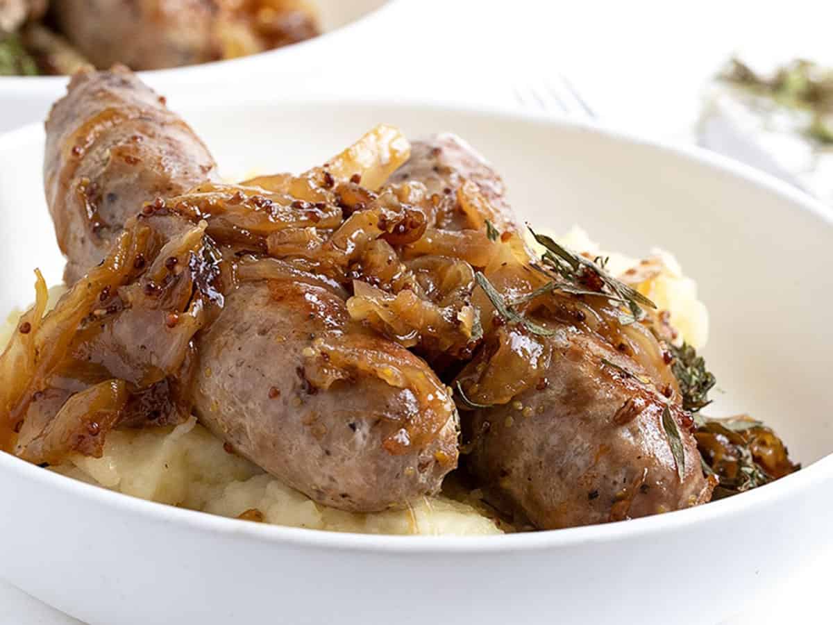 pork sausage in bowl with onions and mashed potatoes