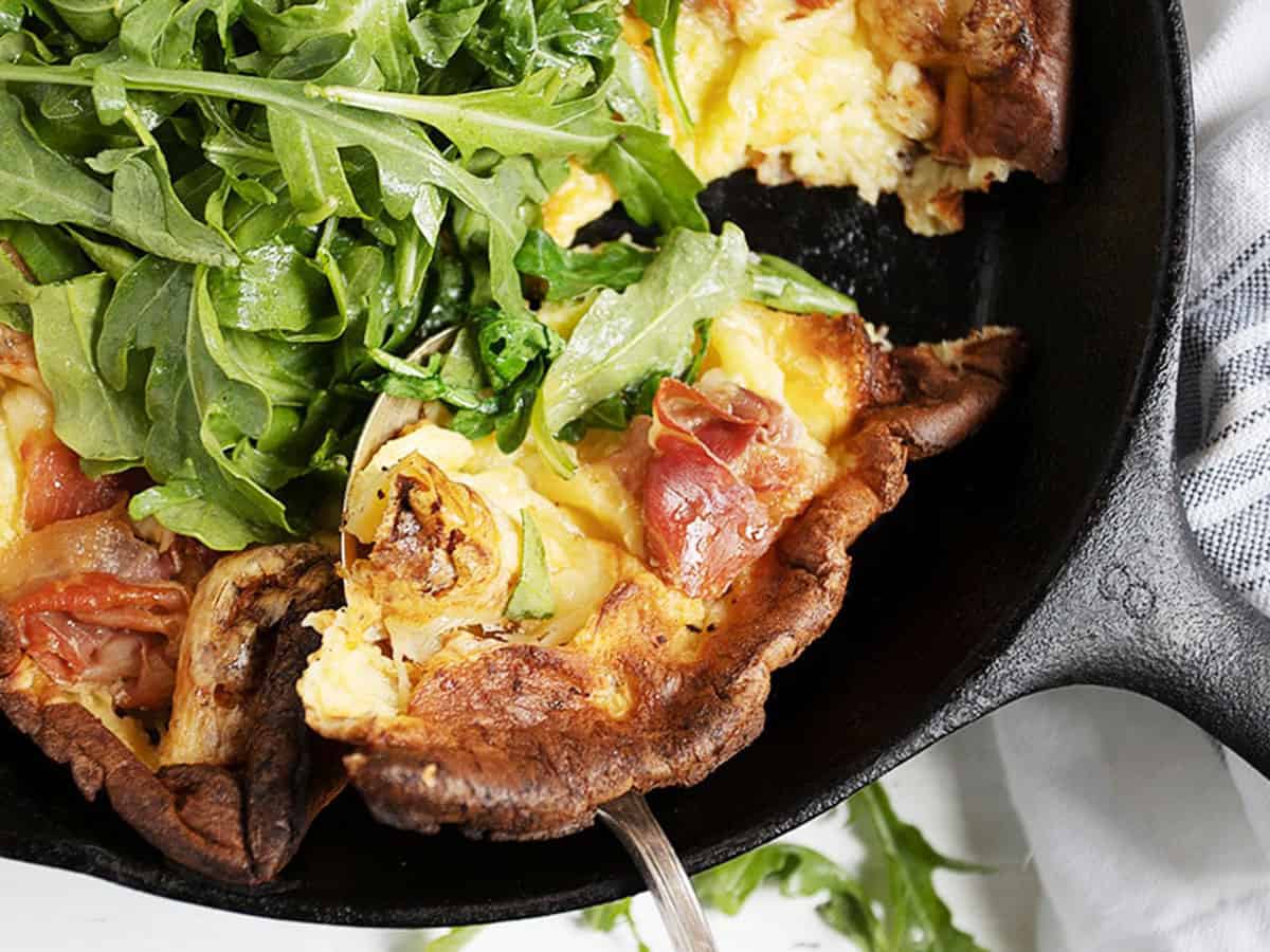 prosciutto Dutch baby in skillet with arugula