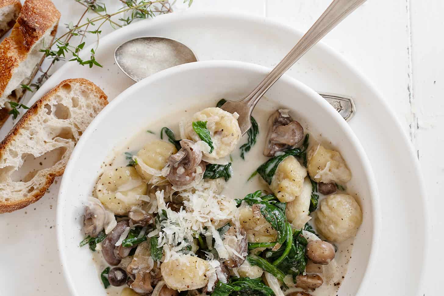 gnocchi with mushrooms and spinach in bowl with fork