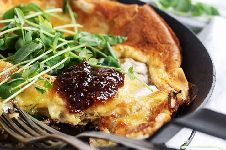 camembert dutch baby with fig jam and sprouts on top