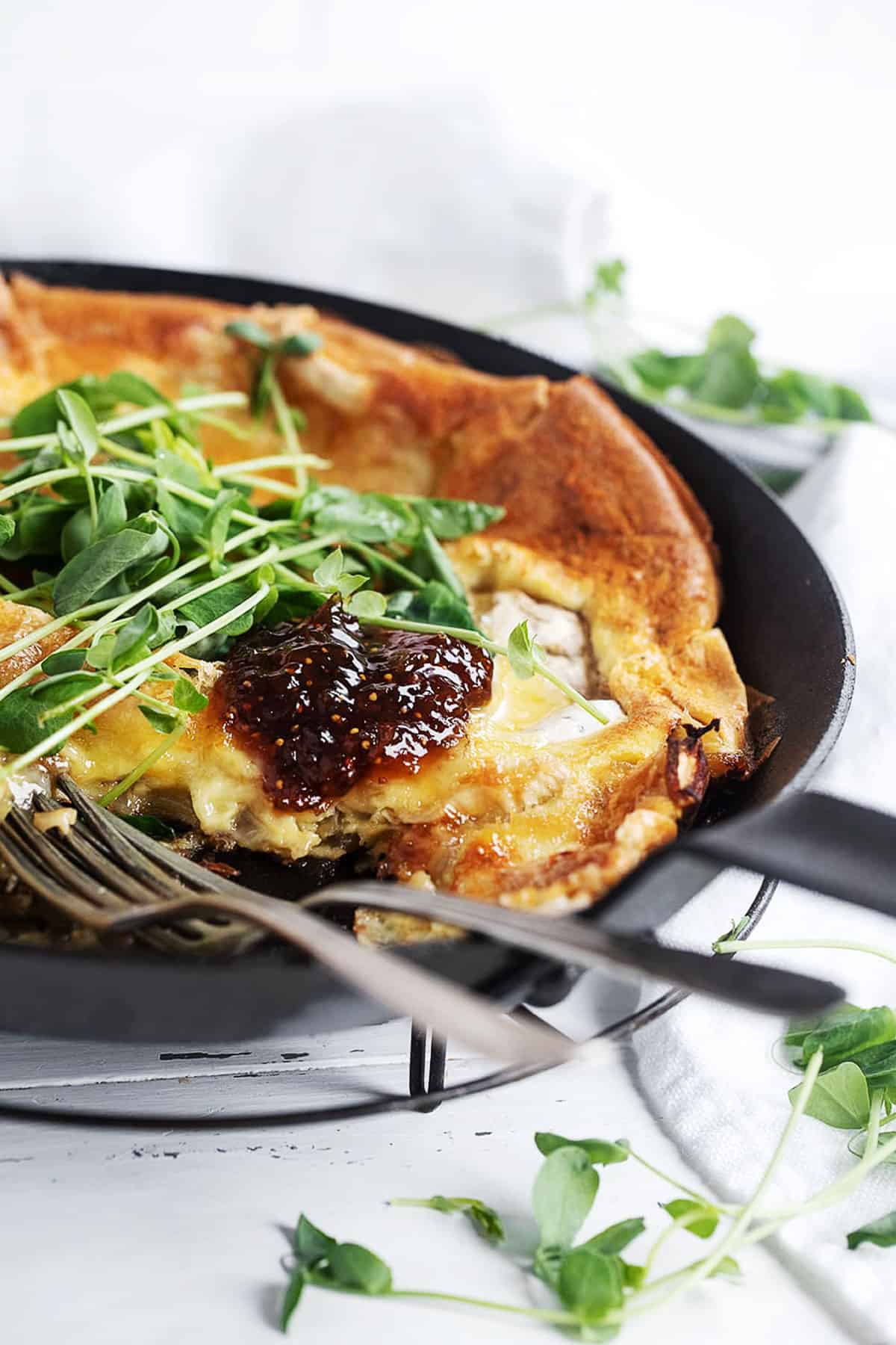 camembert dutch baby with fig jam and sprouts on top
