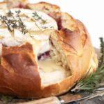 camembert cheese in bread round with cranberry sauce