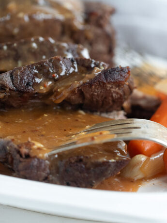 pot roast with horseradish gravy on plate with carrots