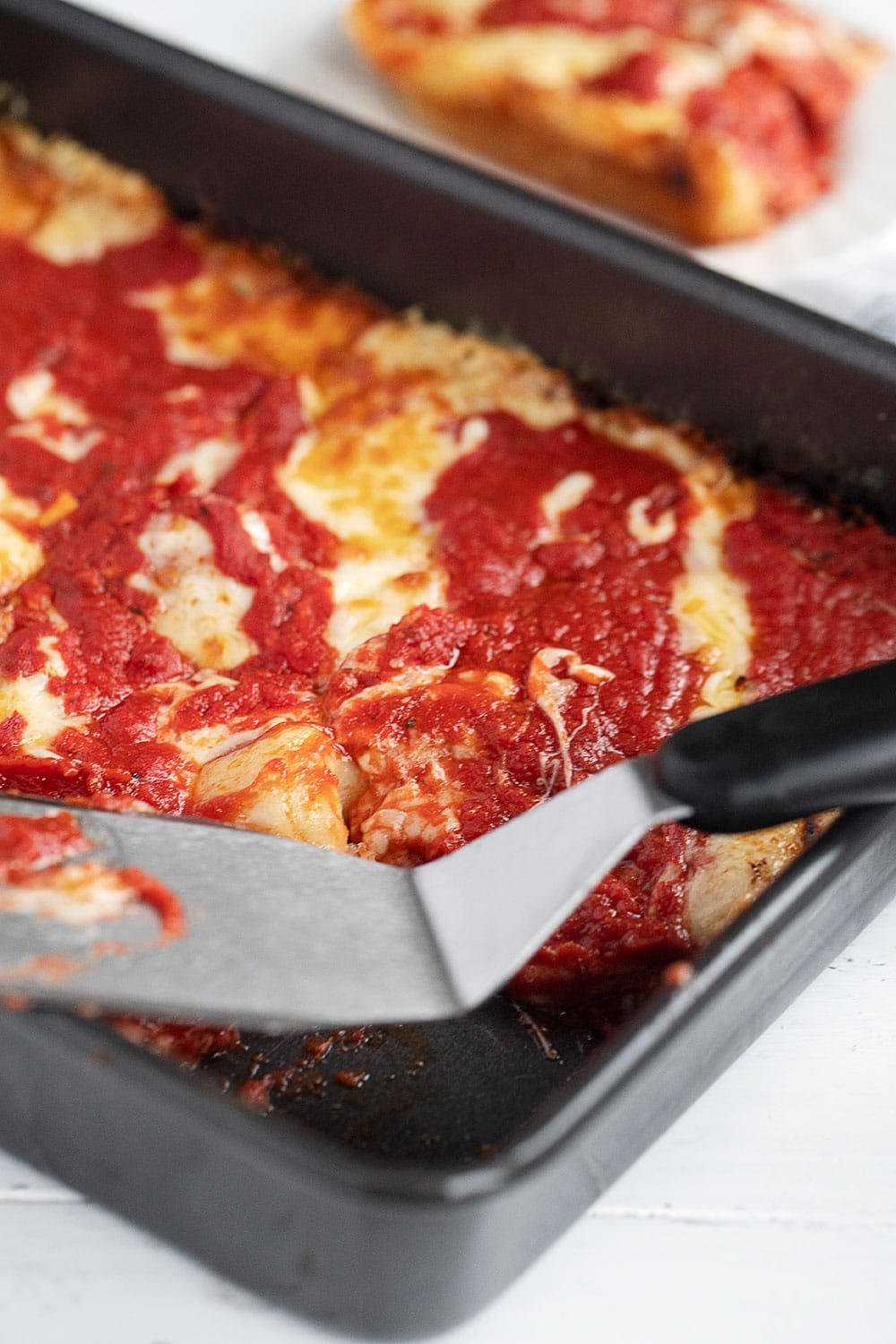 pan of Detroit Style pizza in pan, with spatula