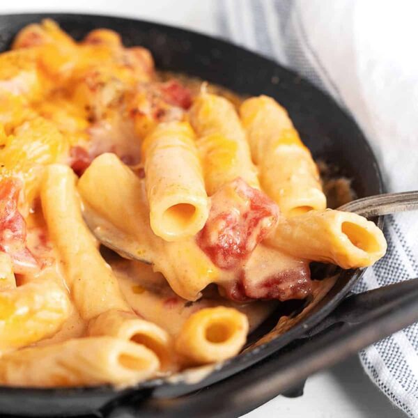 pasta and cheese with tomatoes in small cast iron pan