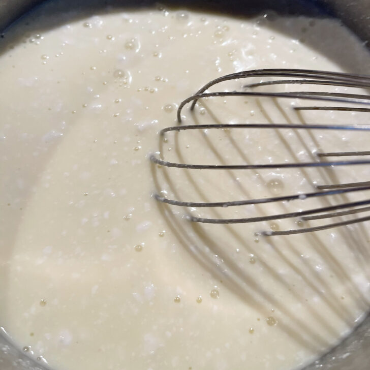 Cooking the mixture while whisking.