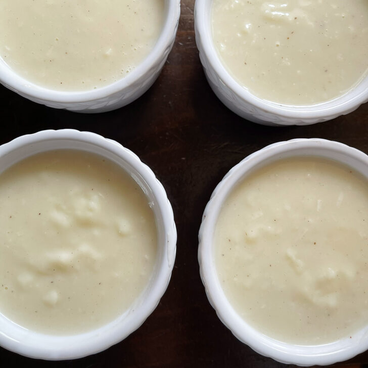 Coconut cream pudding poured into ramekins to set.