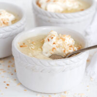 coconut cream pudding in ramekins with whipped cream on top