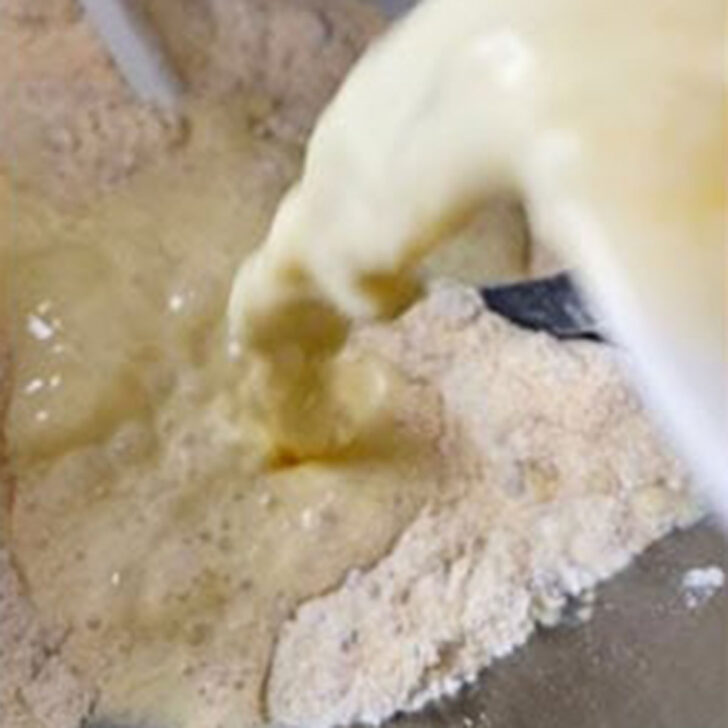 Pouring the wet ingredients into the mixing bowl.