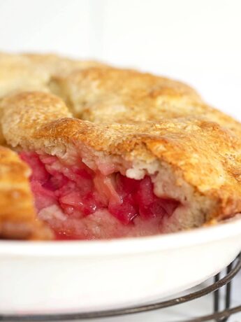 rustic rhubarb cake in pan with slice out
