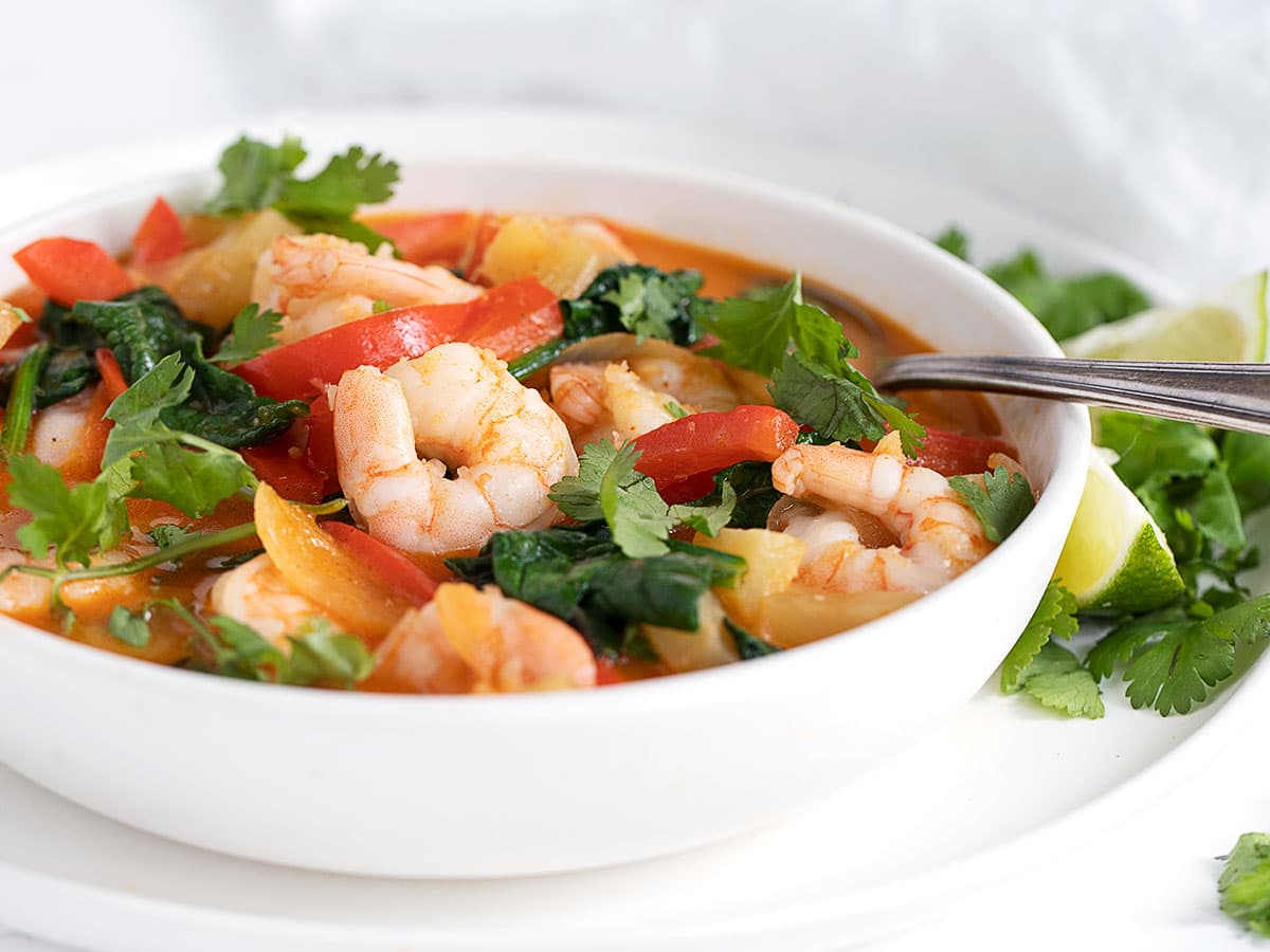 Thai Red Currry Shrimp in white bowl with spoon