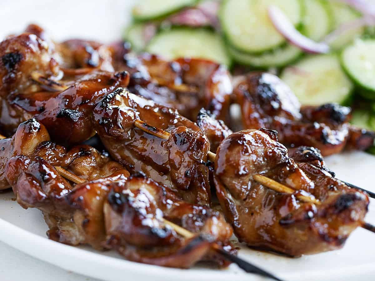 Yakatori chicken skewers on plate with cucumber salad