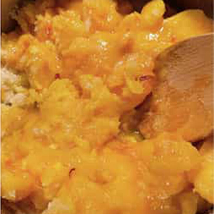 Peaches, sugar and oranges added to a cooking pot.