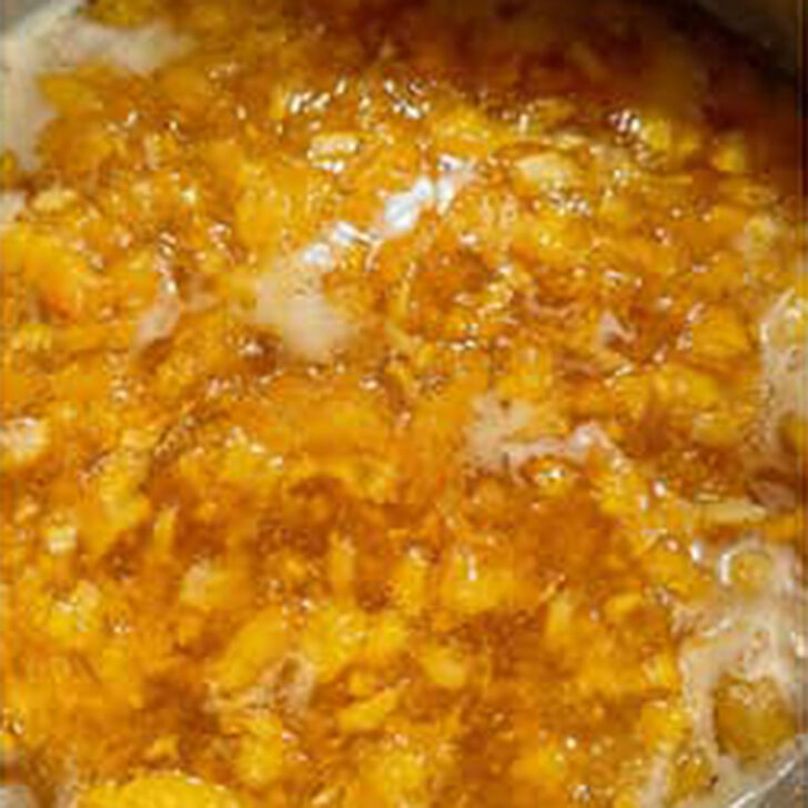 Peach marmalade is boiling in the pot.