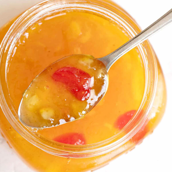 peach marmalade on spoon on top of jar