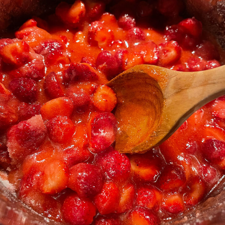 Stirring the jam until the sugar dissolves.