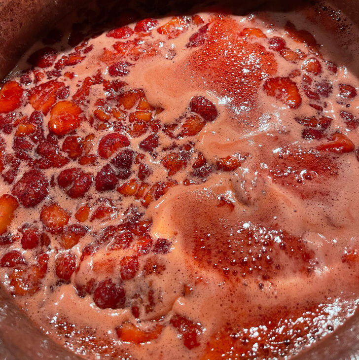 Boiling the jam until it reaches the setting point.