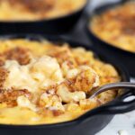 creamy mac and cheese in cast iron skillets with fork