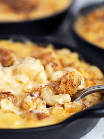 creamy mac and cheese in cast iron skillets with fork