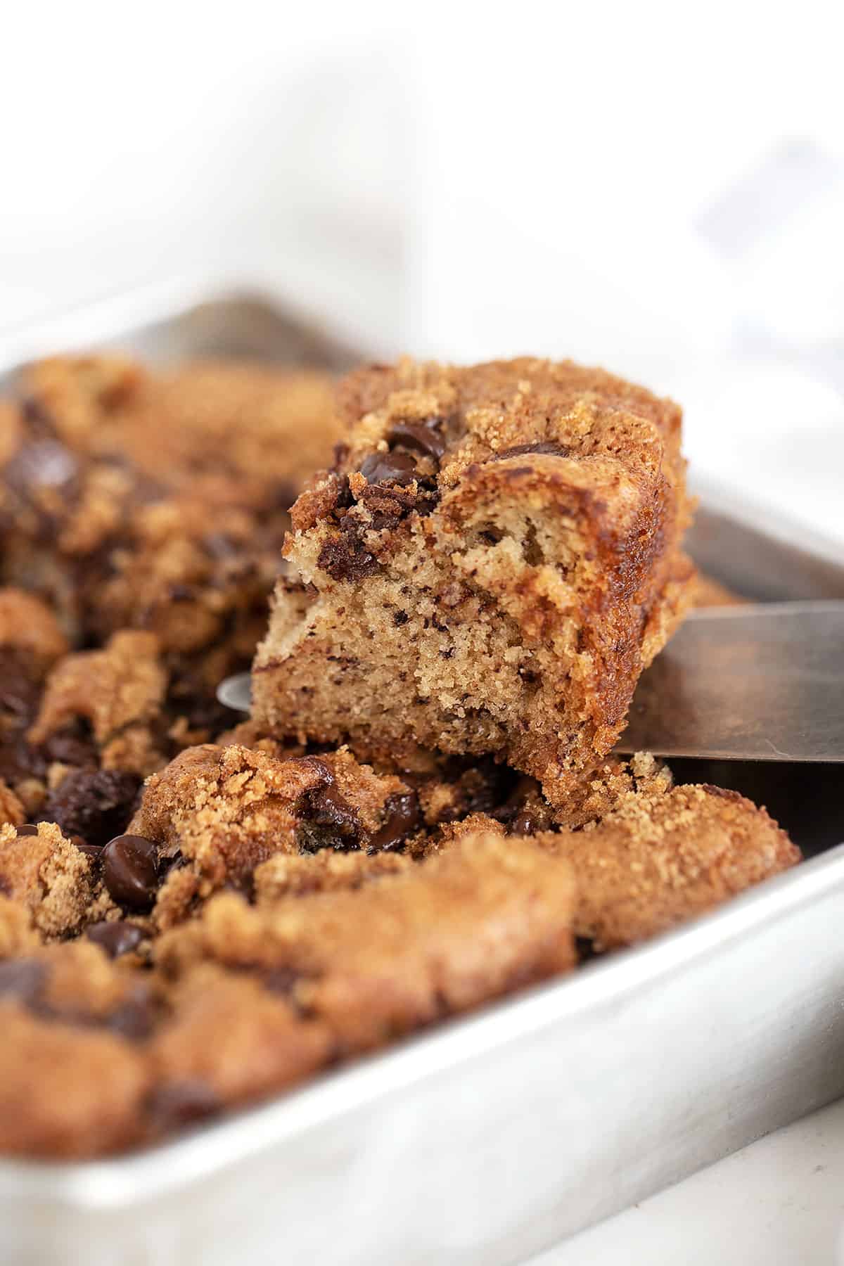 banana chocolate chip snack cake in pan with slice out