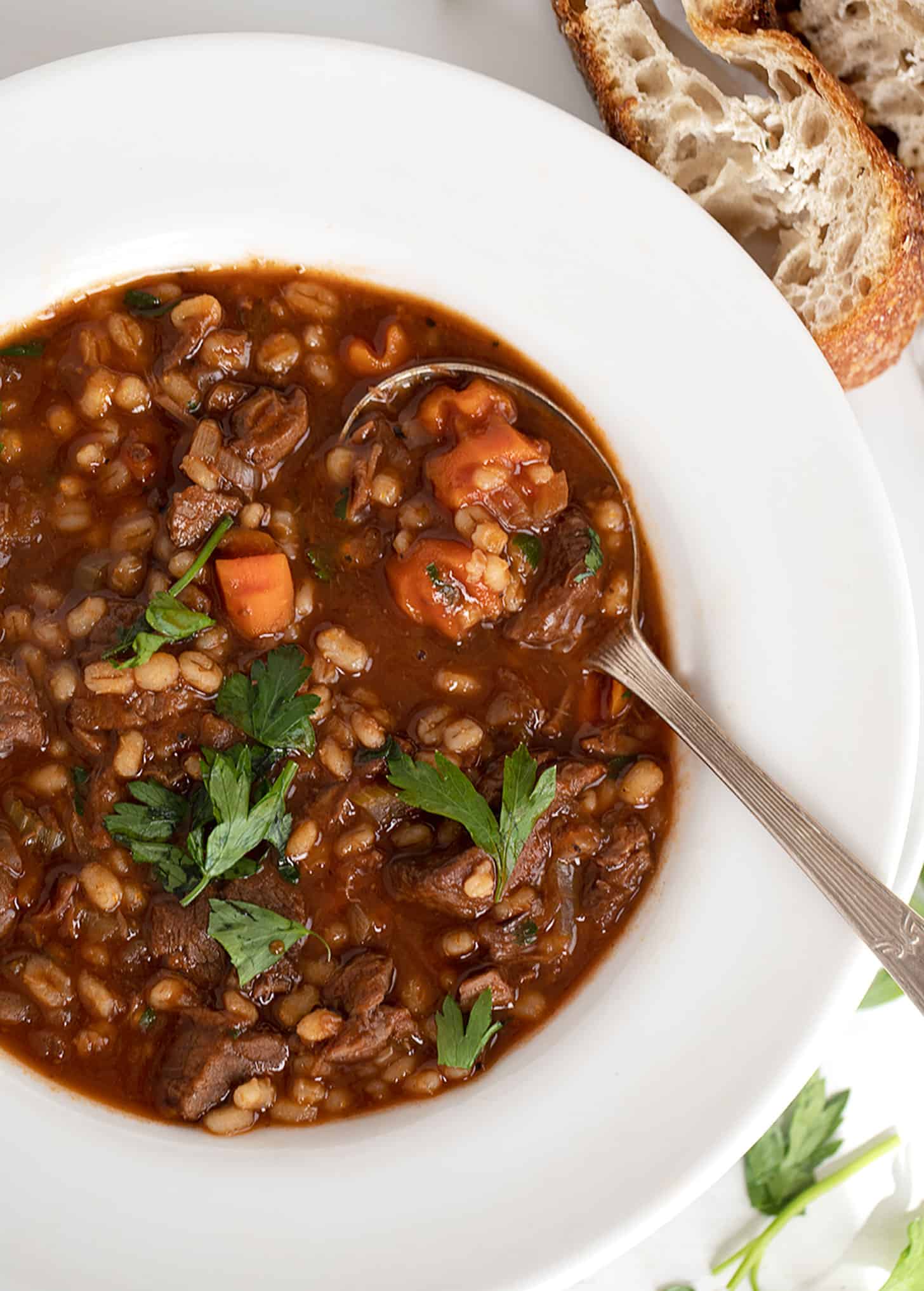 beef and barley soup in white bowl