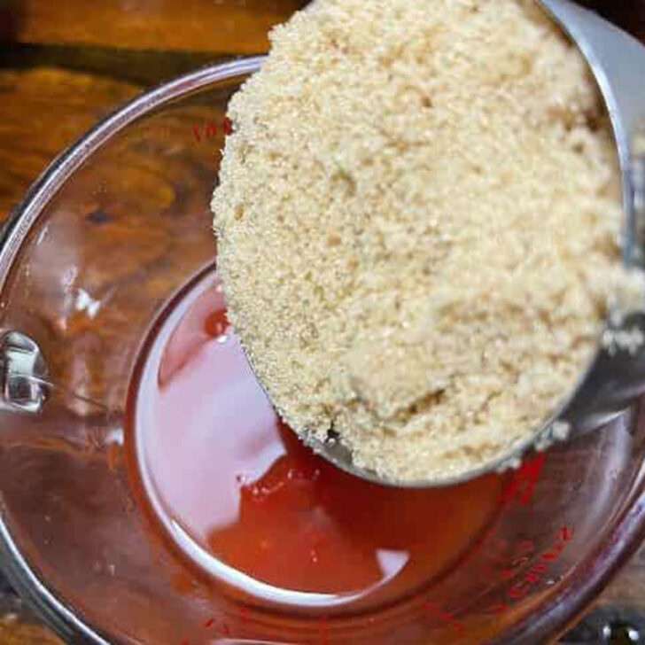 Adding brown sugar to the BBQ sauce.
