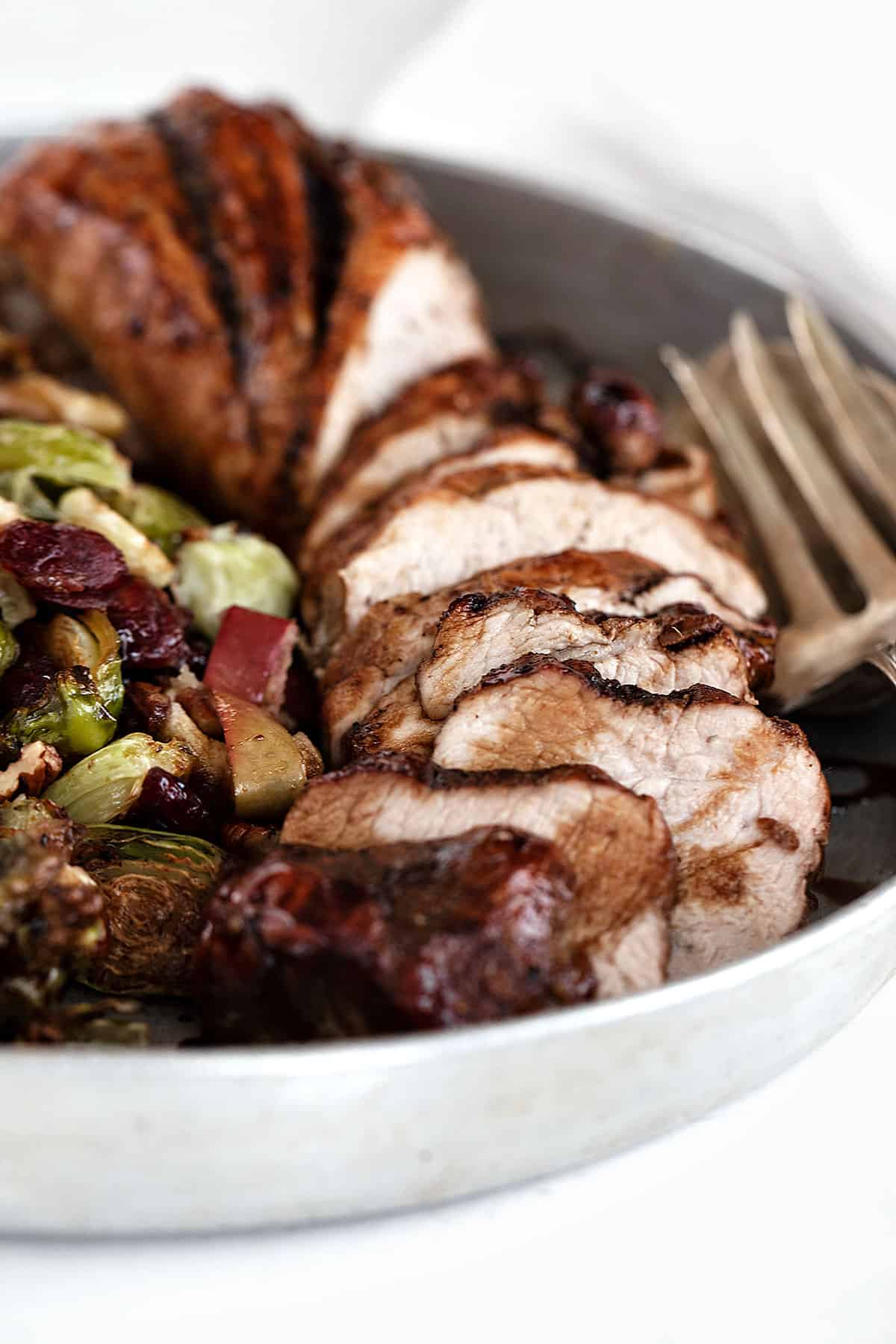 pork tenderloin on serving platter with Brussels sprouts