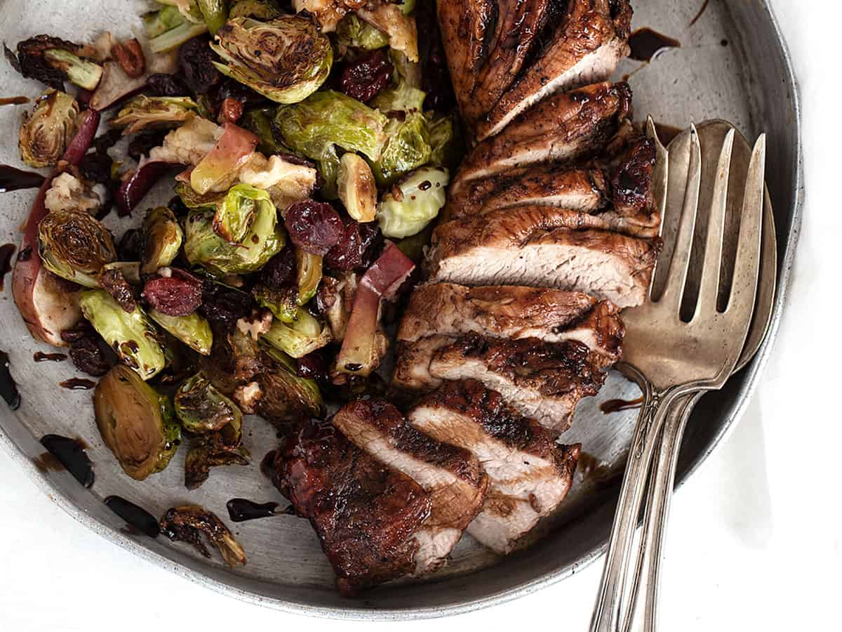 pork tenderloin sliced on platter with Brussels sprouts