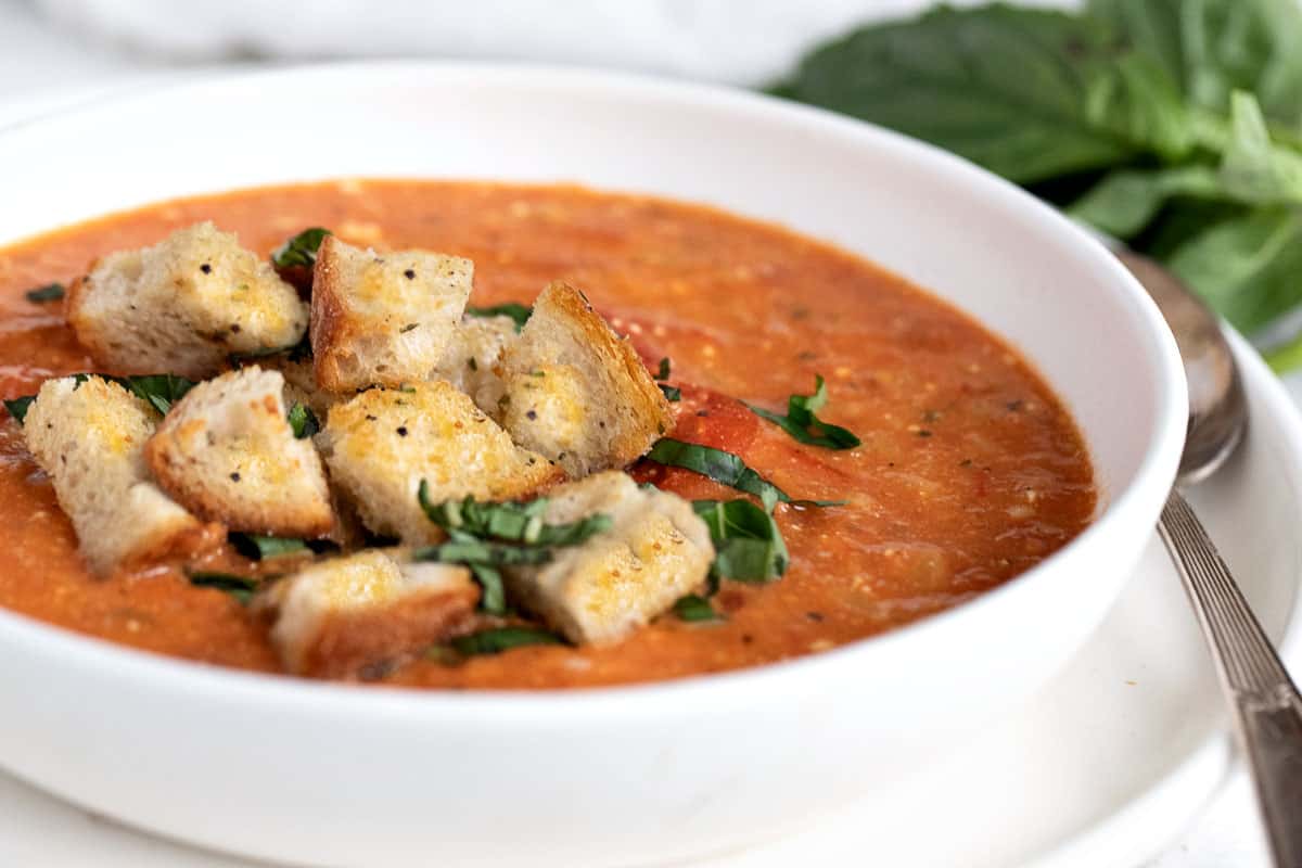 feta tomato orzo soup in bowl with croutons