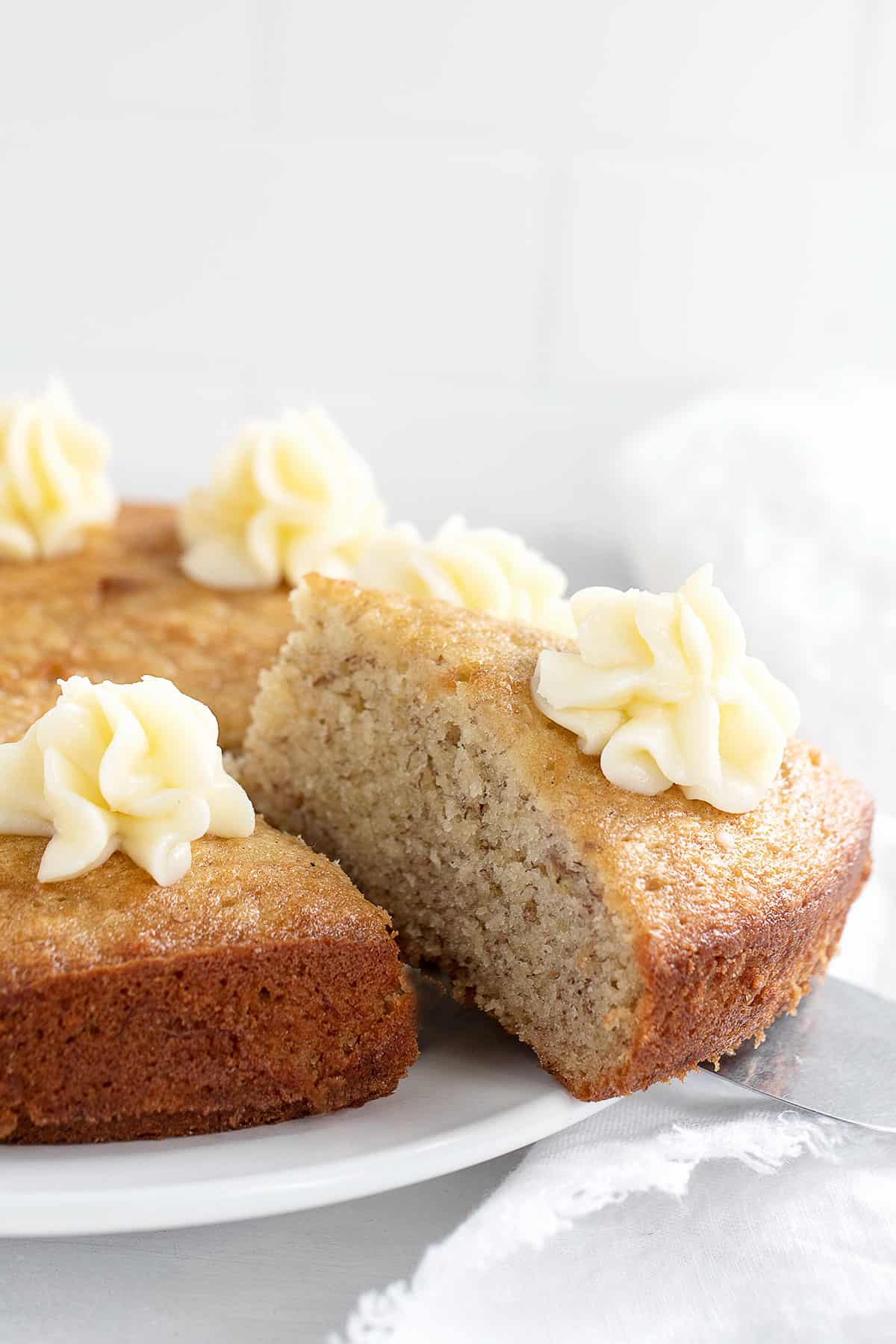 banana snack cake sliced with cream cheese frosting
