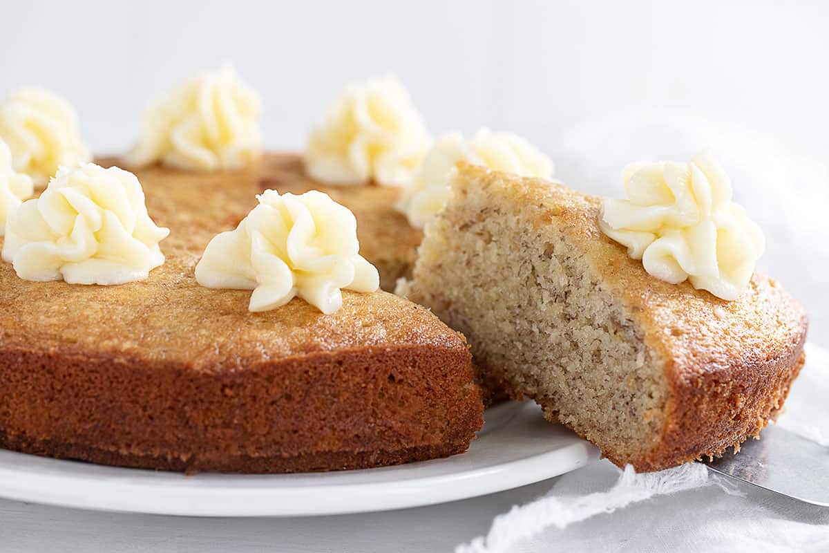 banana snack cake sliced with cream cheese frosting