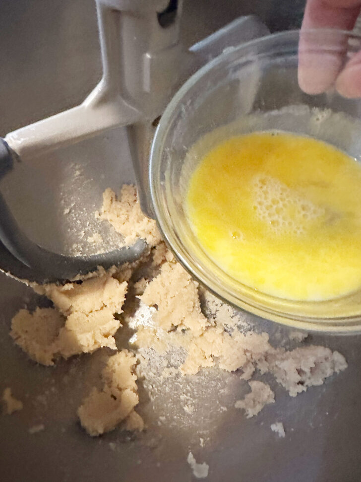 Adding egg to mixing bowl.