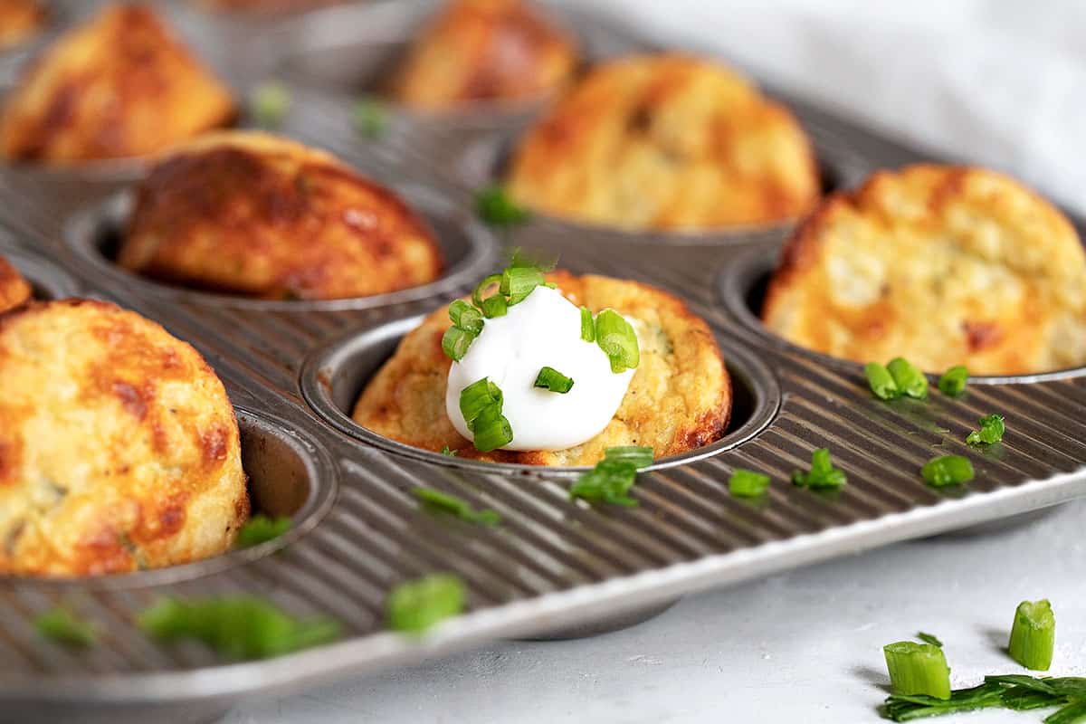 muffin tin mashed potatoes in muffin tin with sour cream and green onion