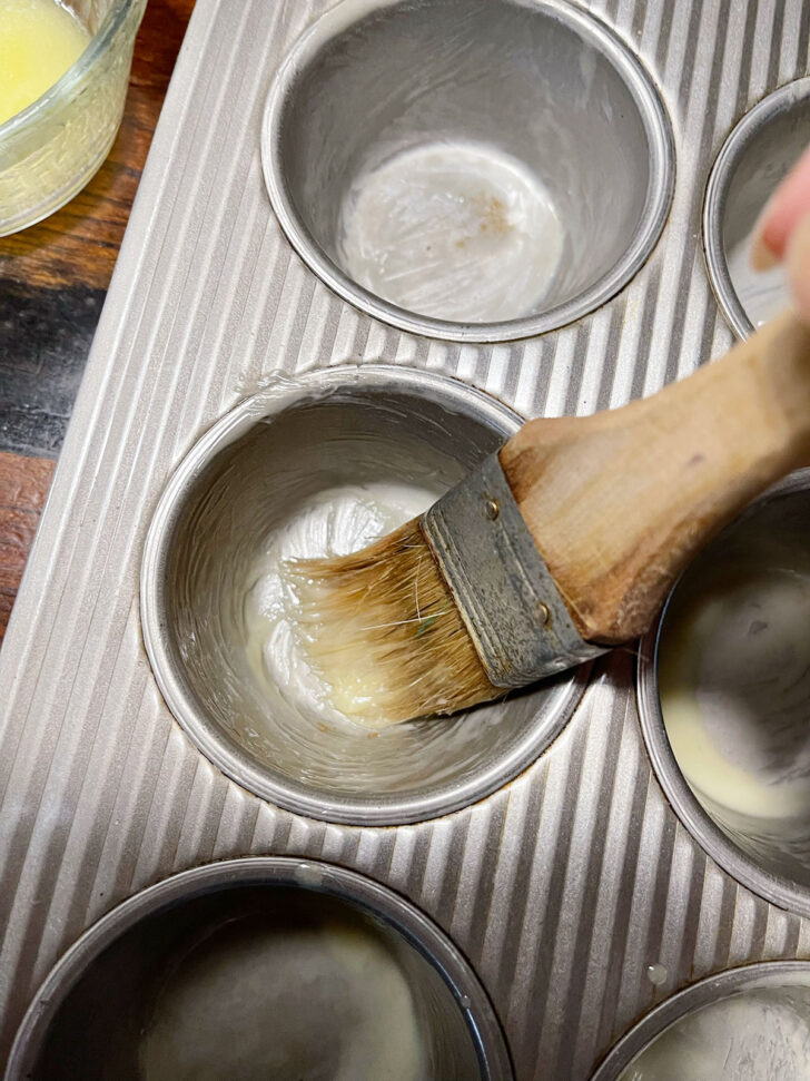 Greasing muffin tins.