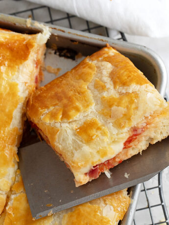 pizza parigina sliced on spatula