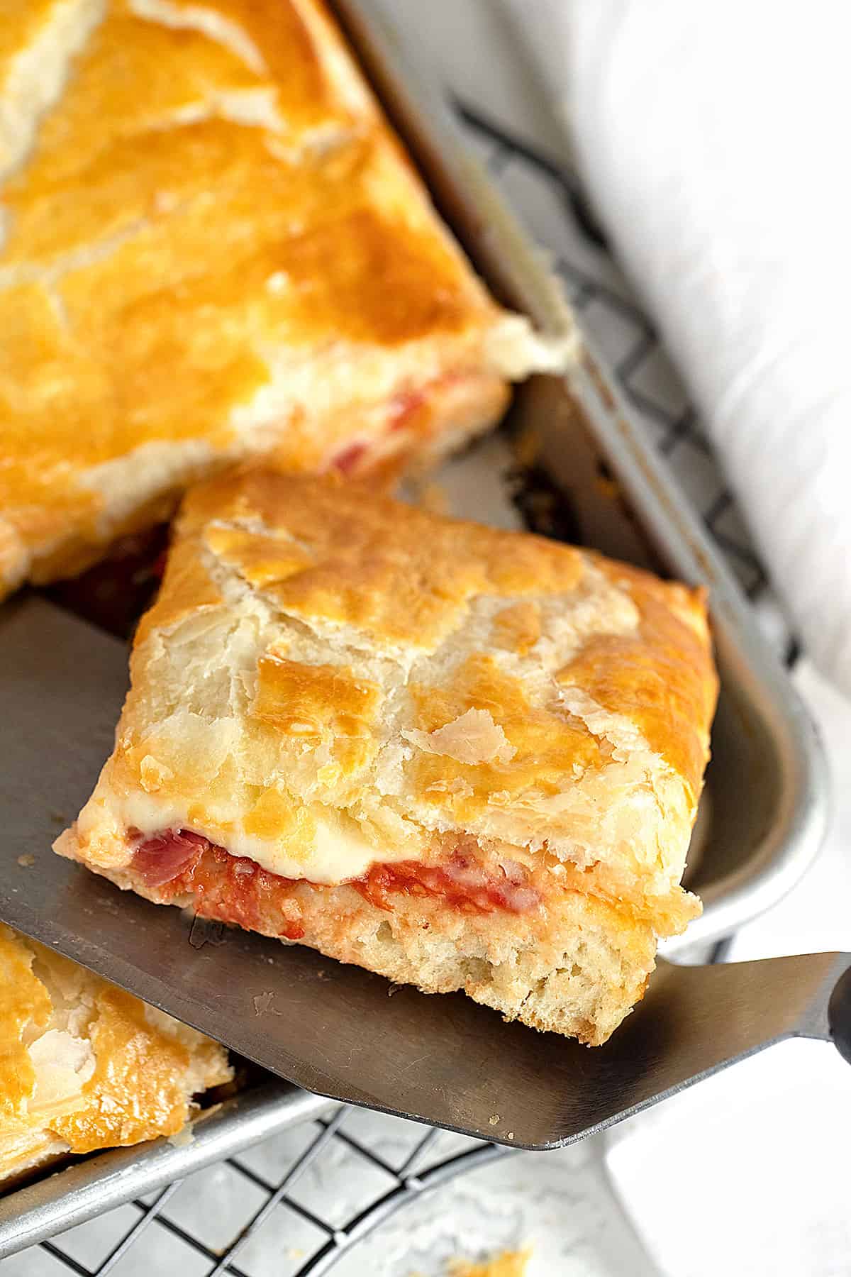 Parisian parigina sheet pan pizza in pan with slice cut out