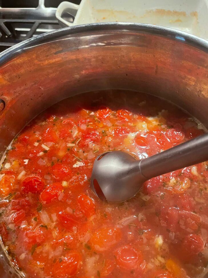 Immersion blender in soup pot.