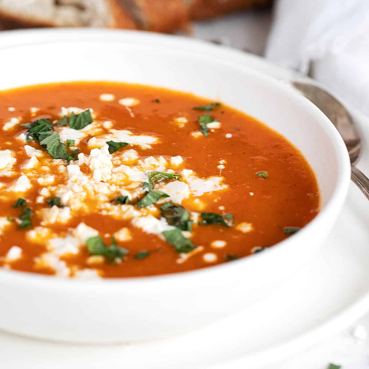 roasted red pepper and tomato soup in white bowl