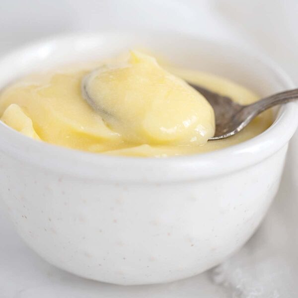 lemon curd in small white bowl with spoon