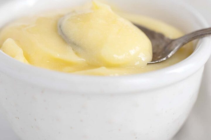 lemon curd in small white bowl with spoon