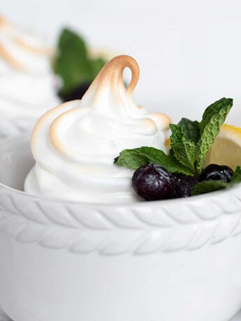 lemon meringue pudding in white ramekins with blueberries