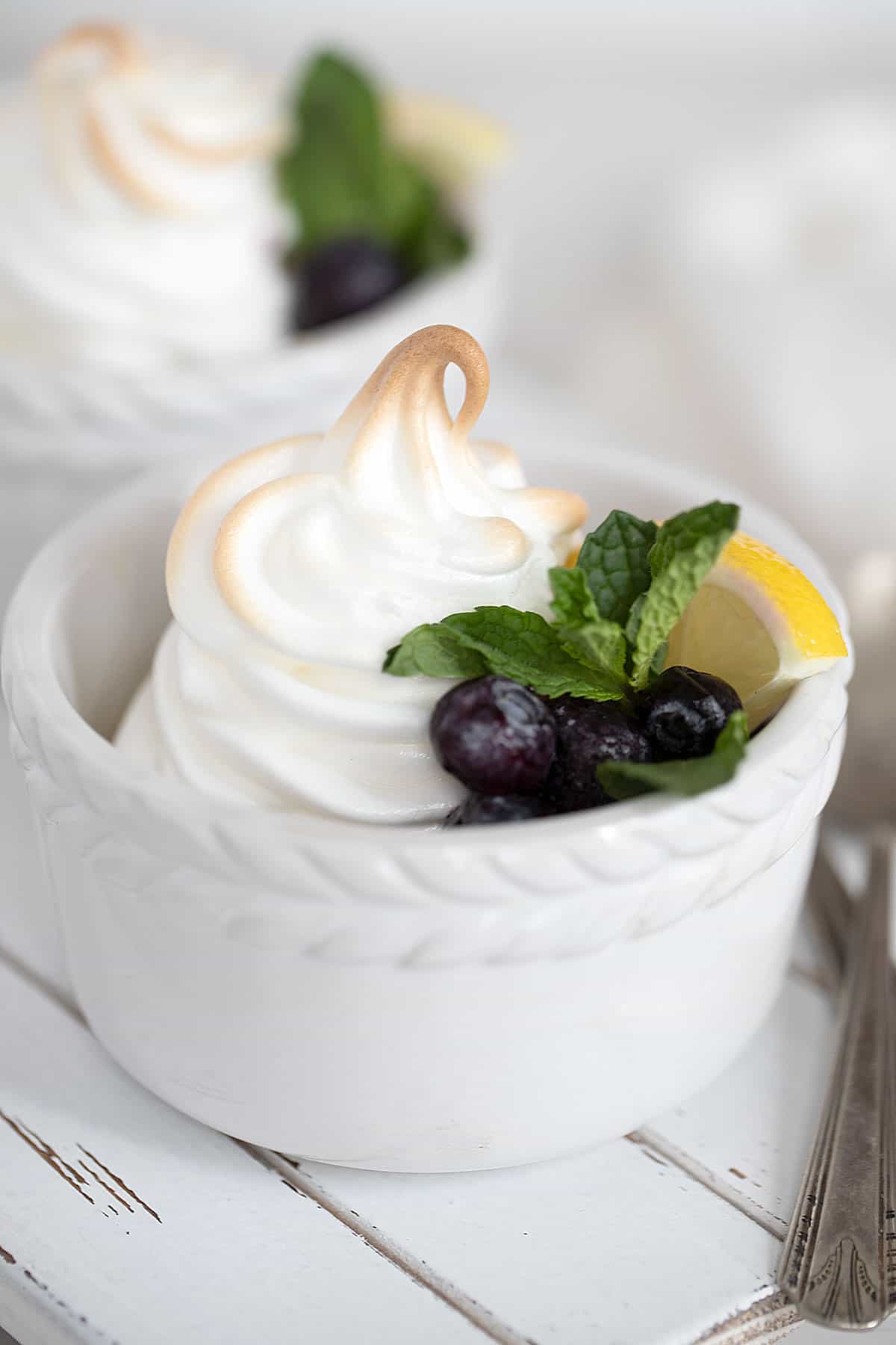 lemon meringue pudding in white ramekins with blueberries