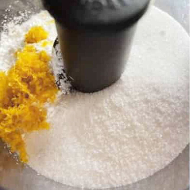 Sugar and lemon zest added to a food processor.