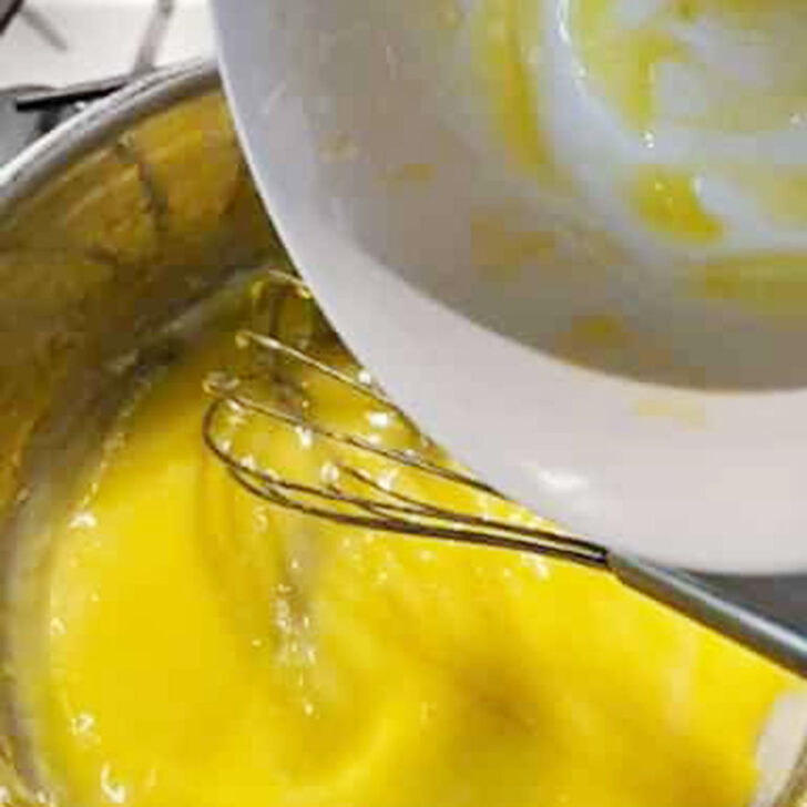 Returning the tempered eggs to the pudding.