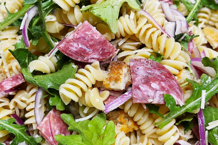 Pasta salad with salami in a bowl.